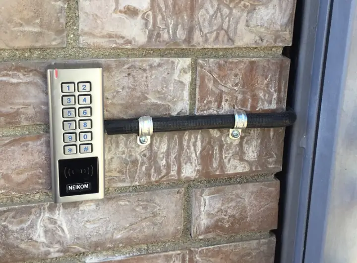 Instalación de un control de accesos Teclado con lector de tarjeta de control de accesos instalado junto a una puerta