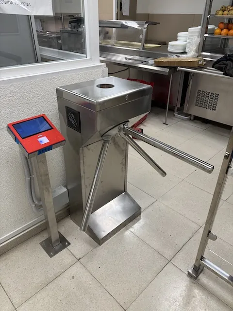 Torno con lector de tarjeta Torno trípode con lector de tarjeta de proximidad en la entrada de un comedor